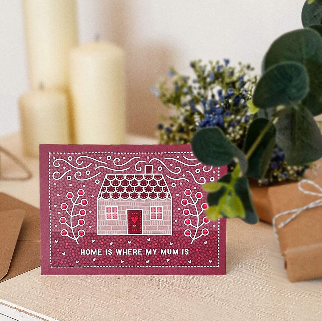 cute pink mother's day card featuring folk-art style house illustration and 'home is where my mum is' message. Supplied with a recycled kraft brown envelope.