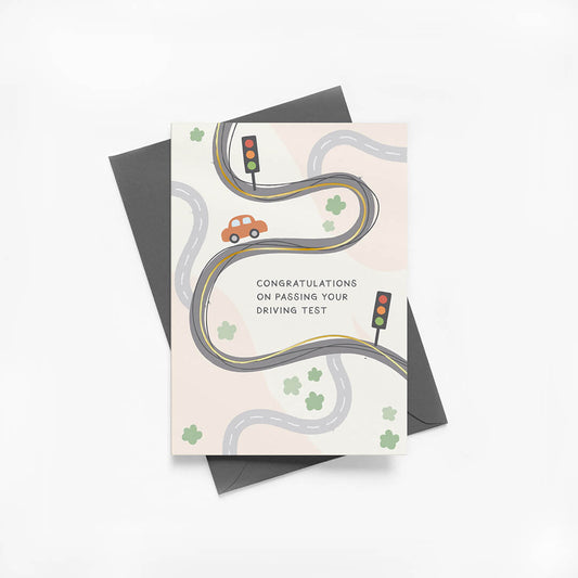 Greeting card with road and car illustrations and grey envelope on white background