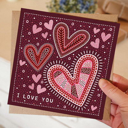 dark red romantic anniversary card featuring illustrated hearts and i love you message. Supplied with recycled kraft brown envelope