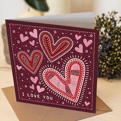 red, pink and white romantic anniversary card, featuring i love you message and illustrated hearts in folk-art style. Supplied with a kraft brown recycled envelope