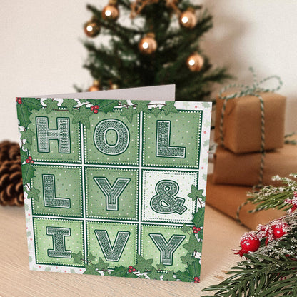 Holly & Ivy Christmas card with 'Holly & Ivy' design in front of a decorated Christmas tree and presents.