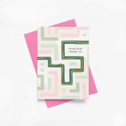 Anniversary card with maze illustration and gold foil details with a pink envelope on a white background