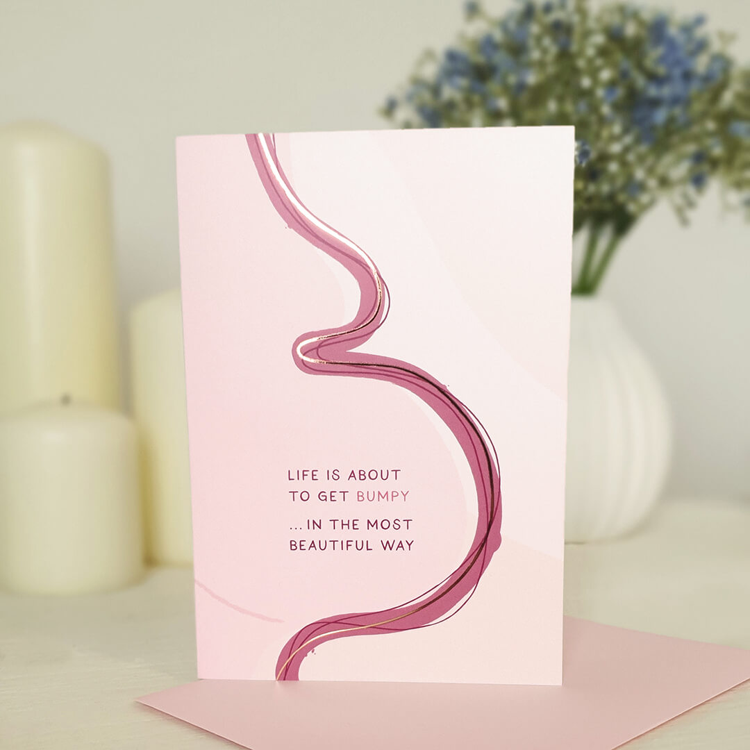 Pregnancy card with pink abstract illustration of female body and text on a light background