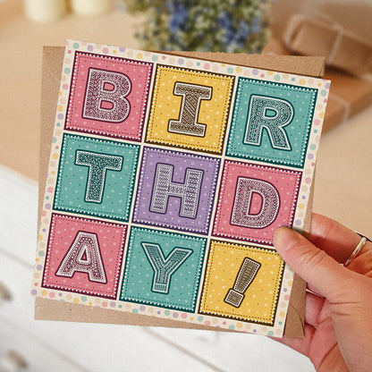 Hand holding colourful girly birthday card Pink yellow and turquoise typographic birthday card Printed on FSC-certified card with kraft brown recycled envelope Blank inside
