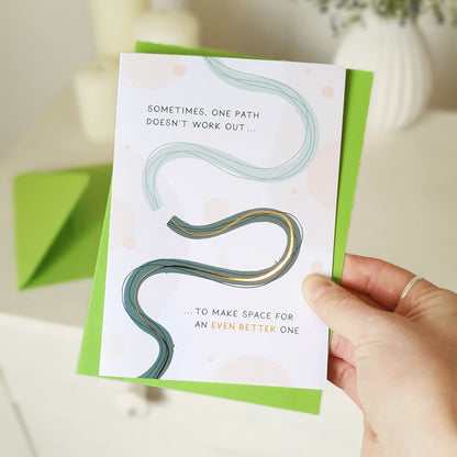 Hand holding a motivational card with a wavy line design and text on a light background