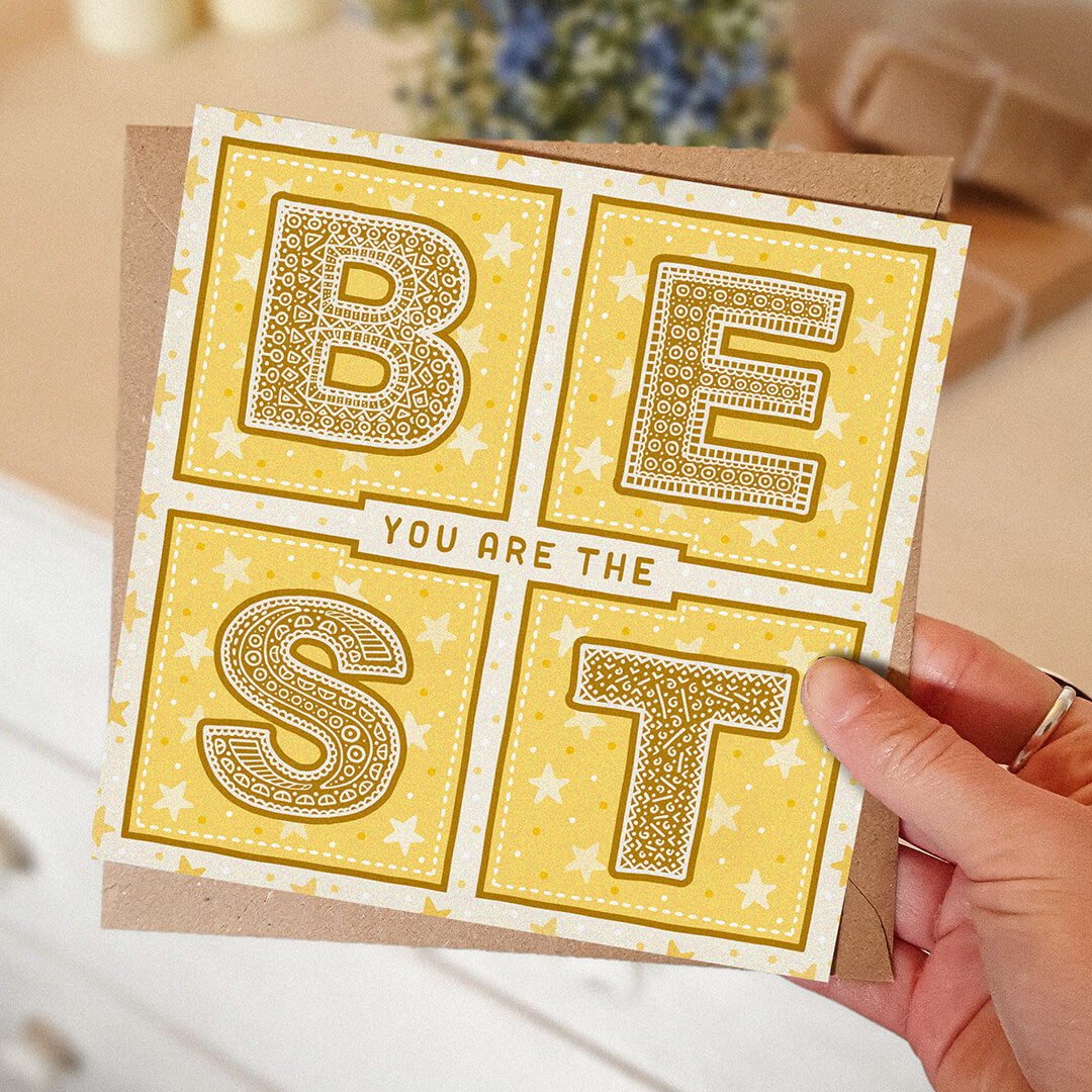 hand holding unique yellow thank you card with you are the best message with a blurred background